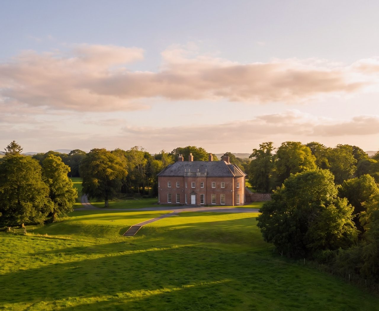 Golden-hour aerial of Newhall House in its parkland