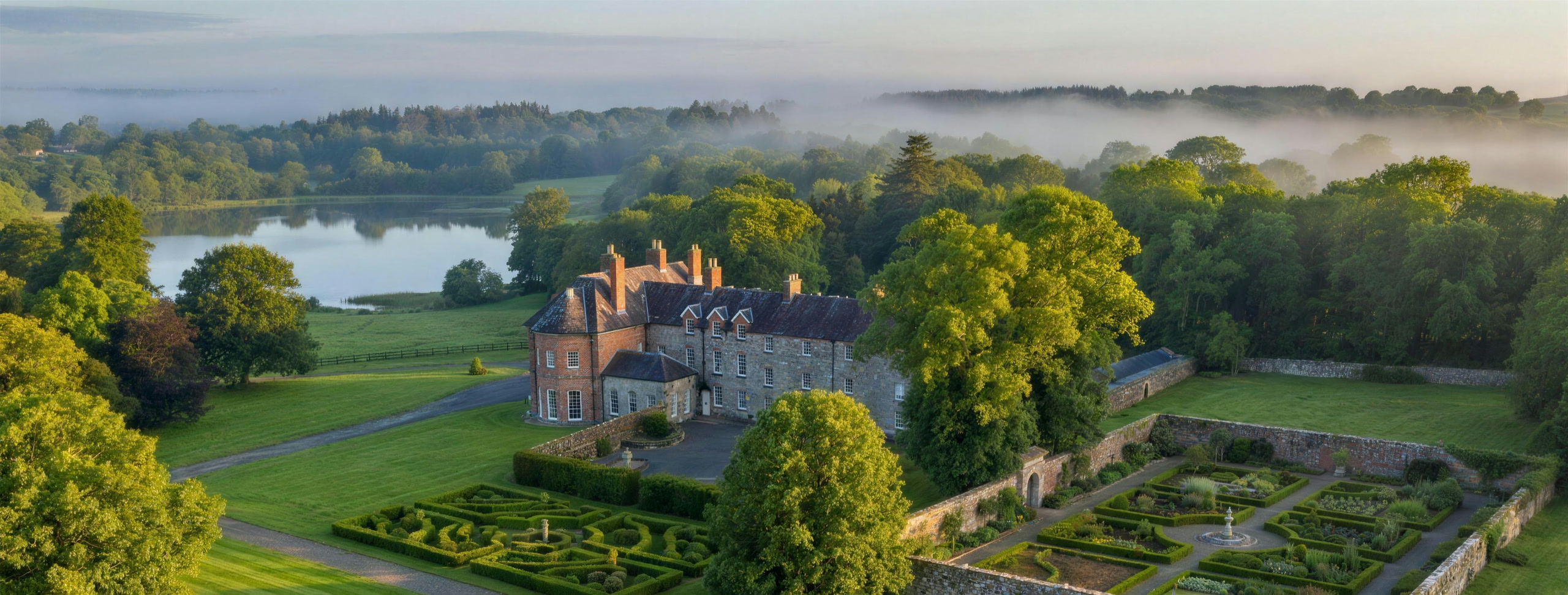 Newhall House, its walled gardens and Killone Lake at misty dawn — the cover of newhall.ie